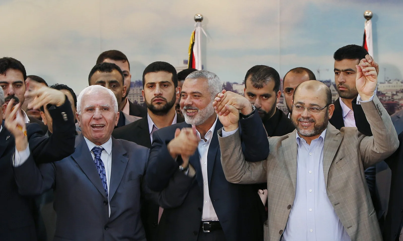 Senior Fatah official Azzam Al-Ahmed, head of the Hamas government Ismail Haniyeh and senior Hamas leader Moussa Abu Marzouq hold their hands after announcing a reconciliation agreement in Gaza City