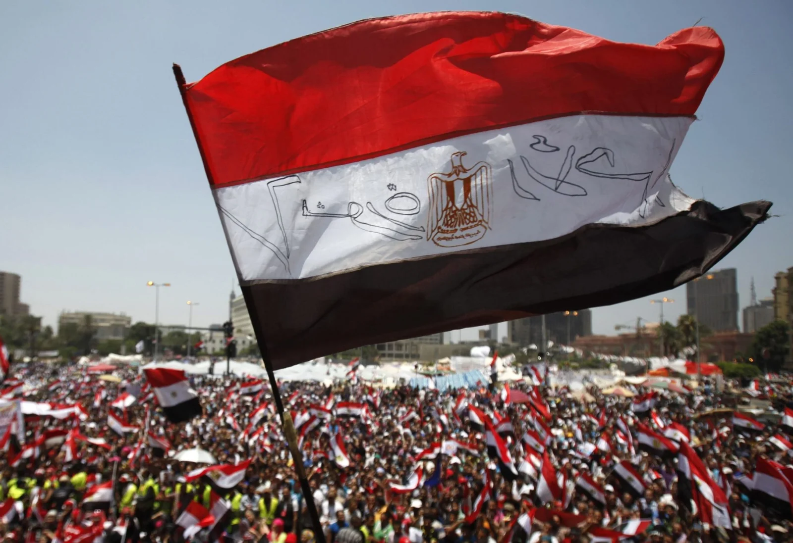 Protesters opposing Egyptian President Mohamed Mursi wave Egyptian flags and shout slogans against him and members of the Muslim Brotherhood at Tahrir square in Cairo