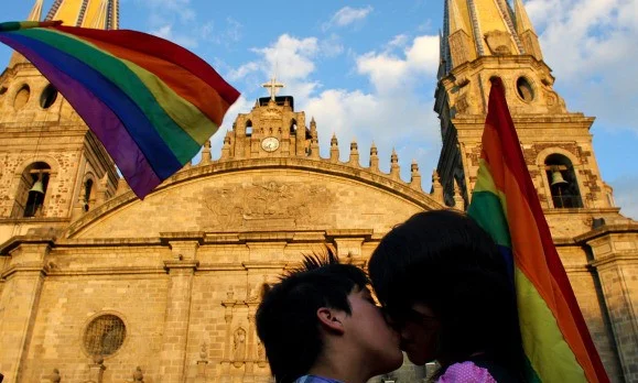 A gay couple kisses in front of the Metr